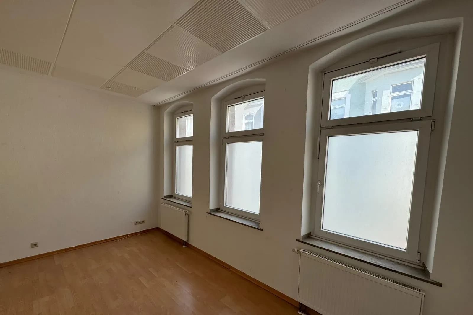 Heller Raum mit hohen Sprossenfenstern im Stadthaus